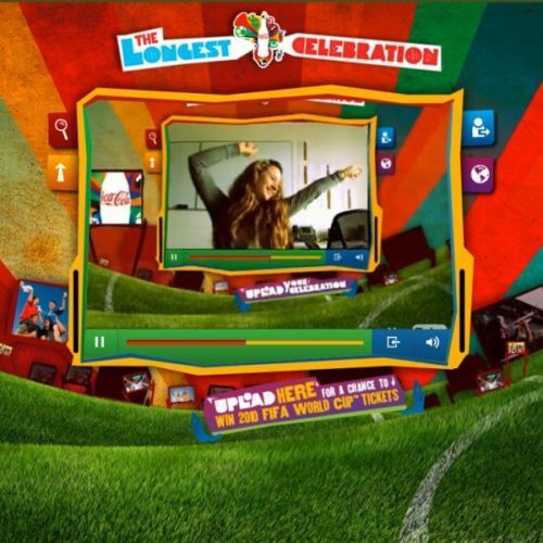 A website banner with a video frame at the center showing a woman raising her hands, surrounded by vibrant colors and an ad for winning FIFA World Cup tickets at the bottom.