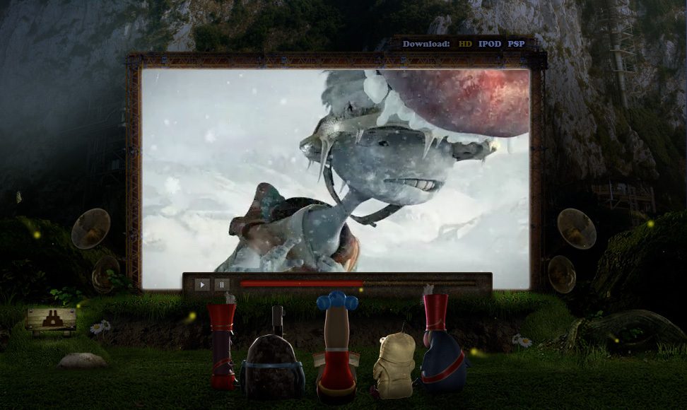 Four figures are seated outdoors watching an animated movie on a large screen. The movie depicts a character in a snowy landscape. The setting appears to be a natural, possibly forested area.